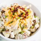 potato salad with cheese and bacon in white bowl