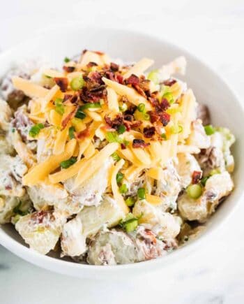 potato salad with cheese and bacon in white bowl