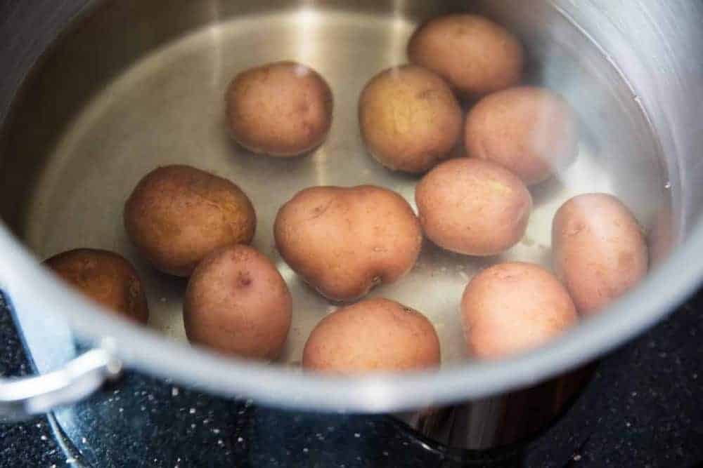 Red potatoes in pot of water.