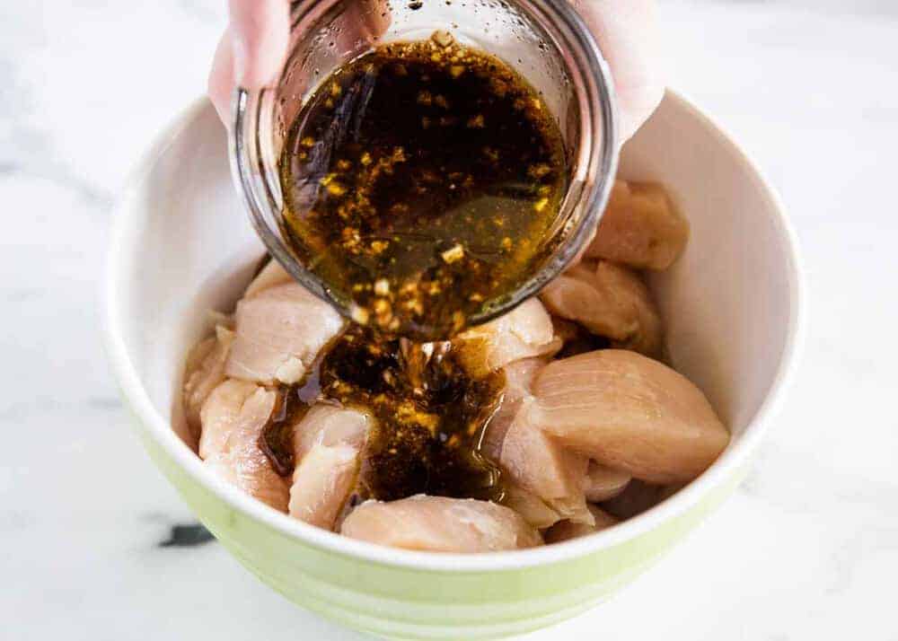 Marinade over chicken in bowl.