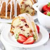 strawberry sour cream cake on white plate with strawberries