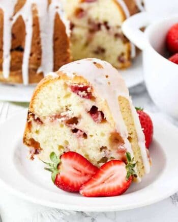 strawberry sour cream cake on white plate with strawberries