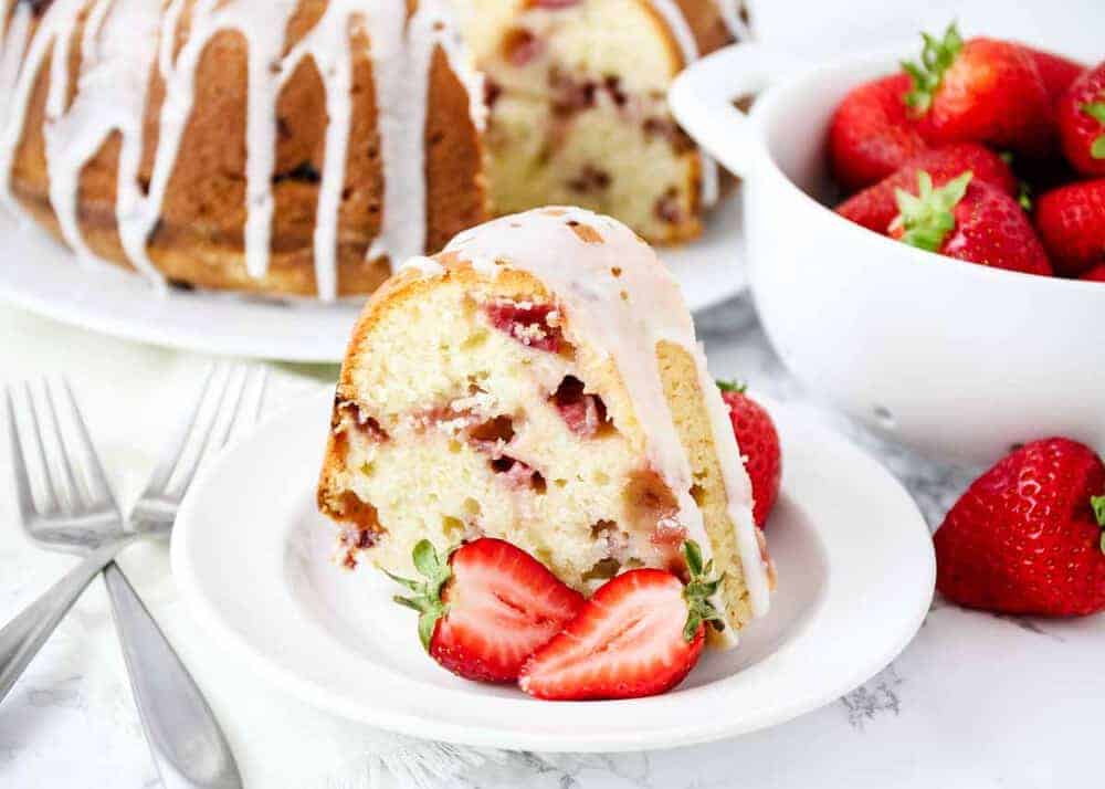Strawberry sour cream cake on white plate.