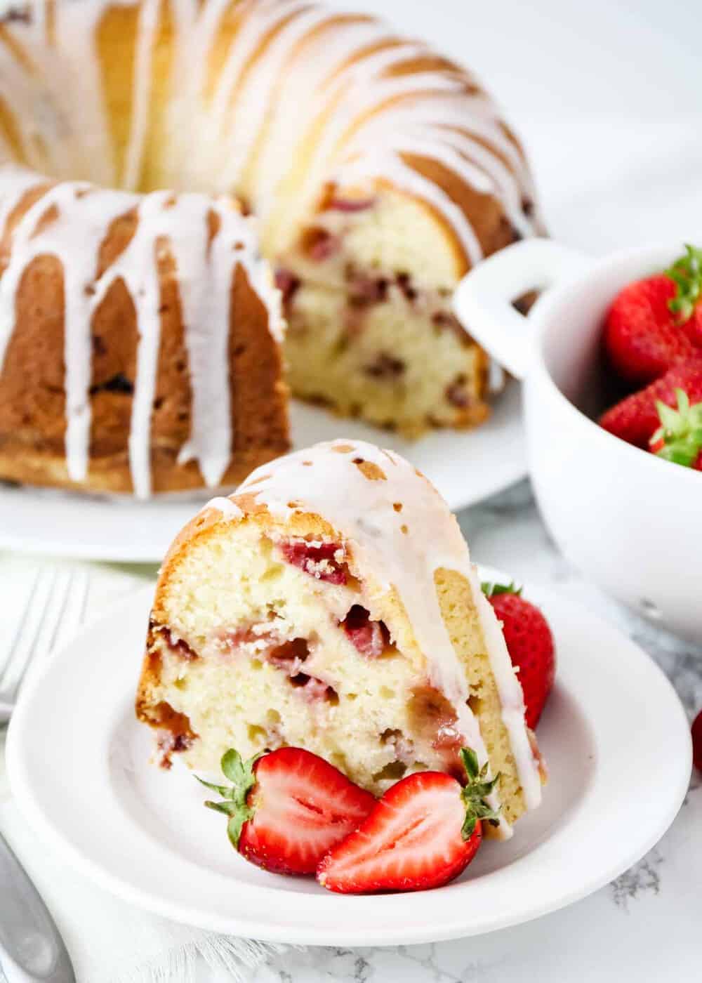 Slice of strawberry sour cream cake on white plate.