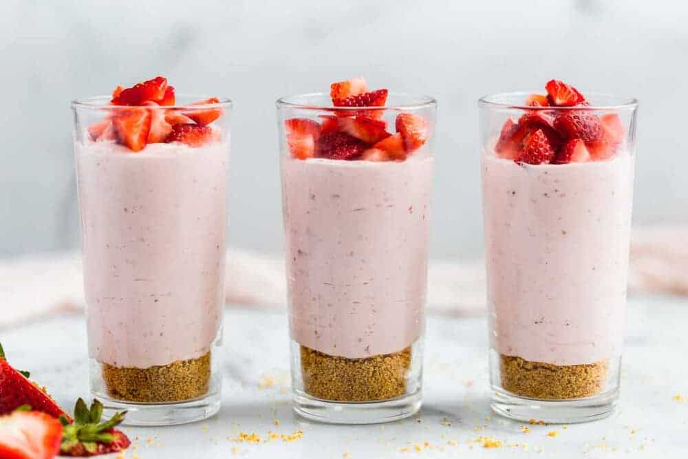 Strawberry mousse in glass cups with fresh strawberries on top.