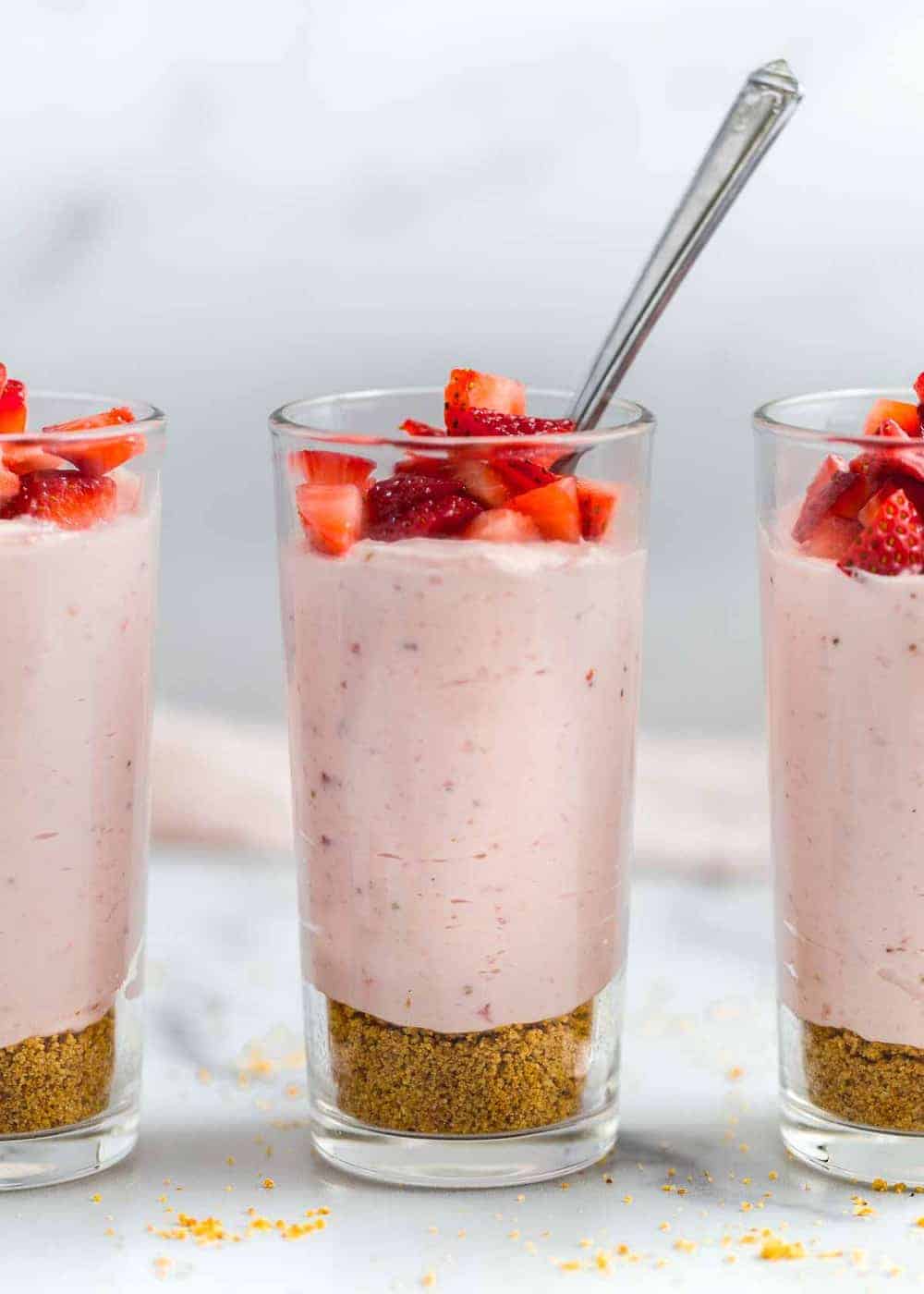 Strawberry mousse in a glass cup with a spoon.