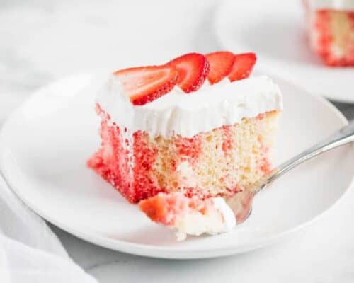 strawberry poke cake on a white plate