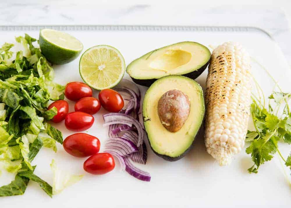 Taco salad ingredients on a cutting board.