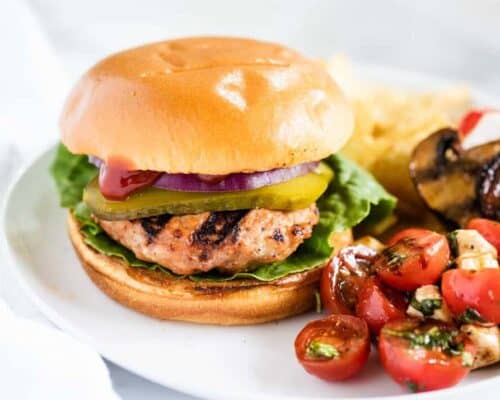 turkey burger on a white plate with salad