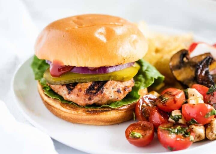 turkey burger on a white plate with salad