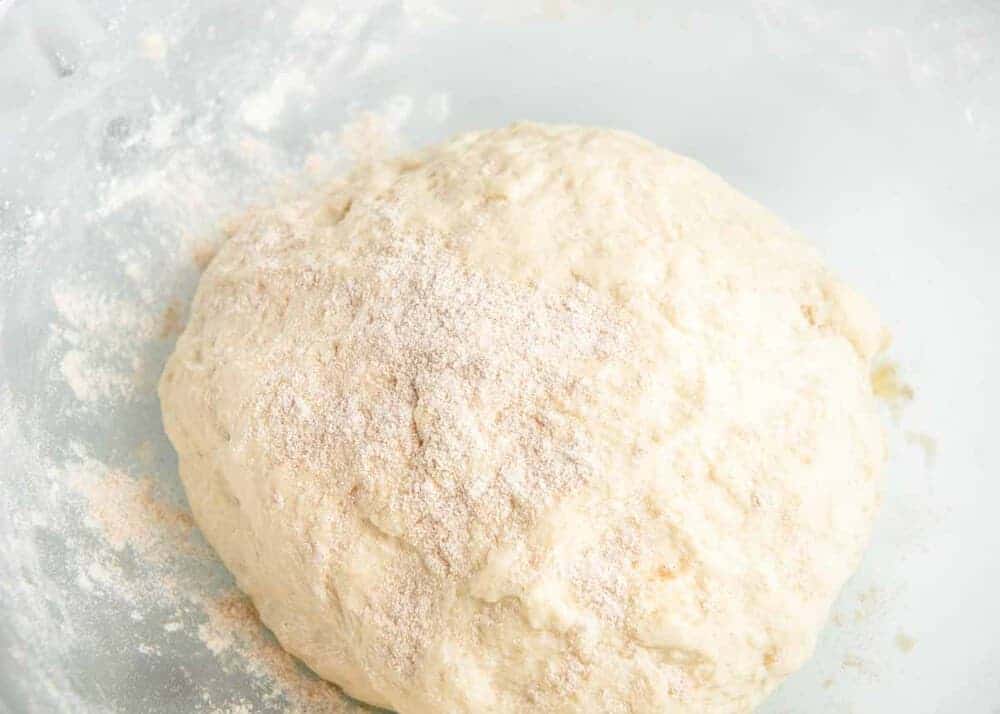 Whole wheat pizza dough ball on flour.