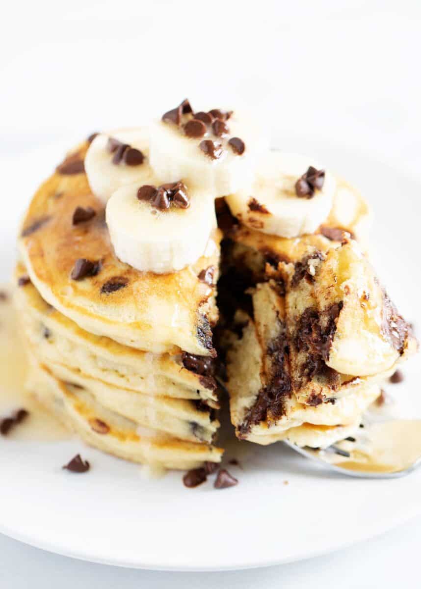 Stack of chocolate chip pancakes on white plate.