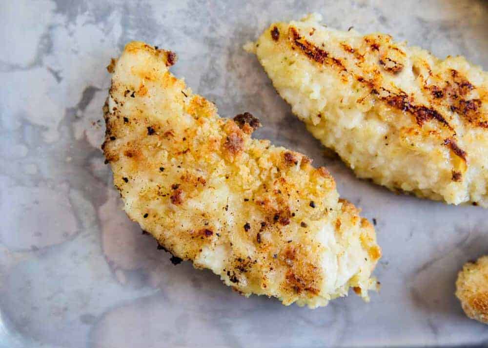 Baked chicken tenders on baking sheet.