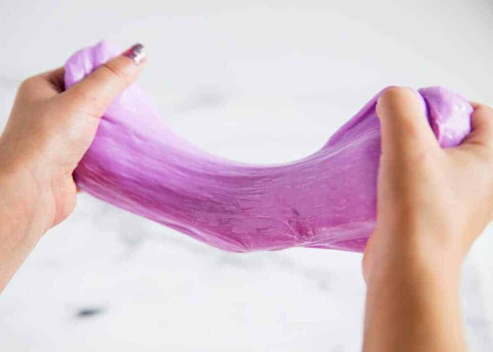 Purple slime being pulled by hands.