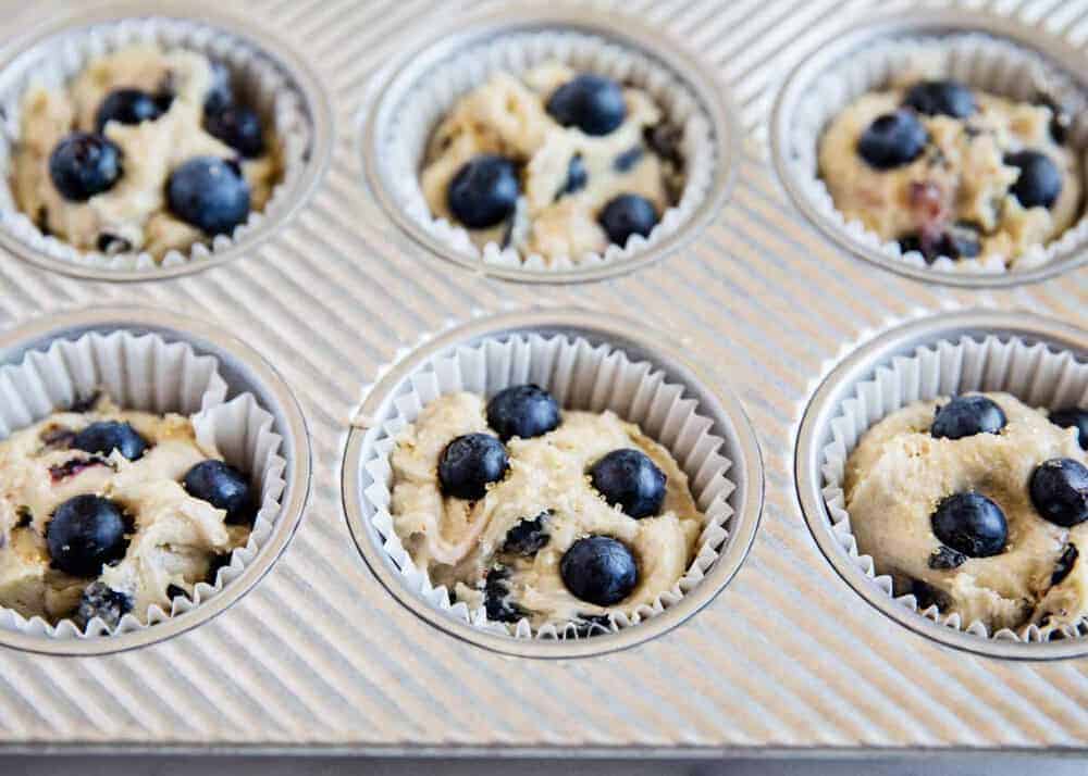 Blueberry muffin batter in liners in pan.