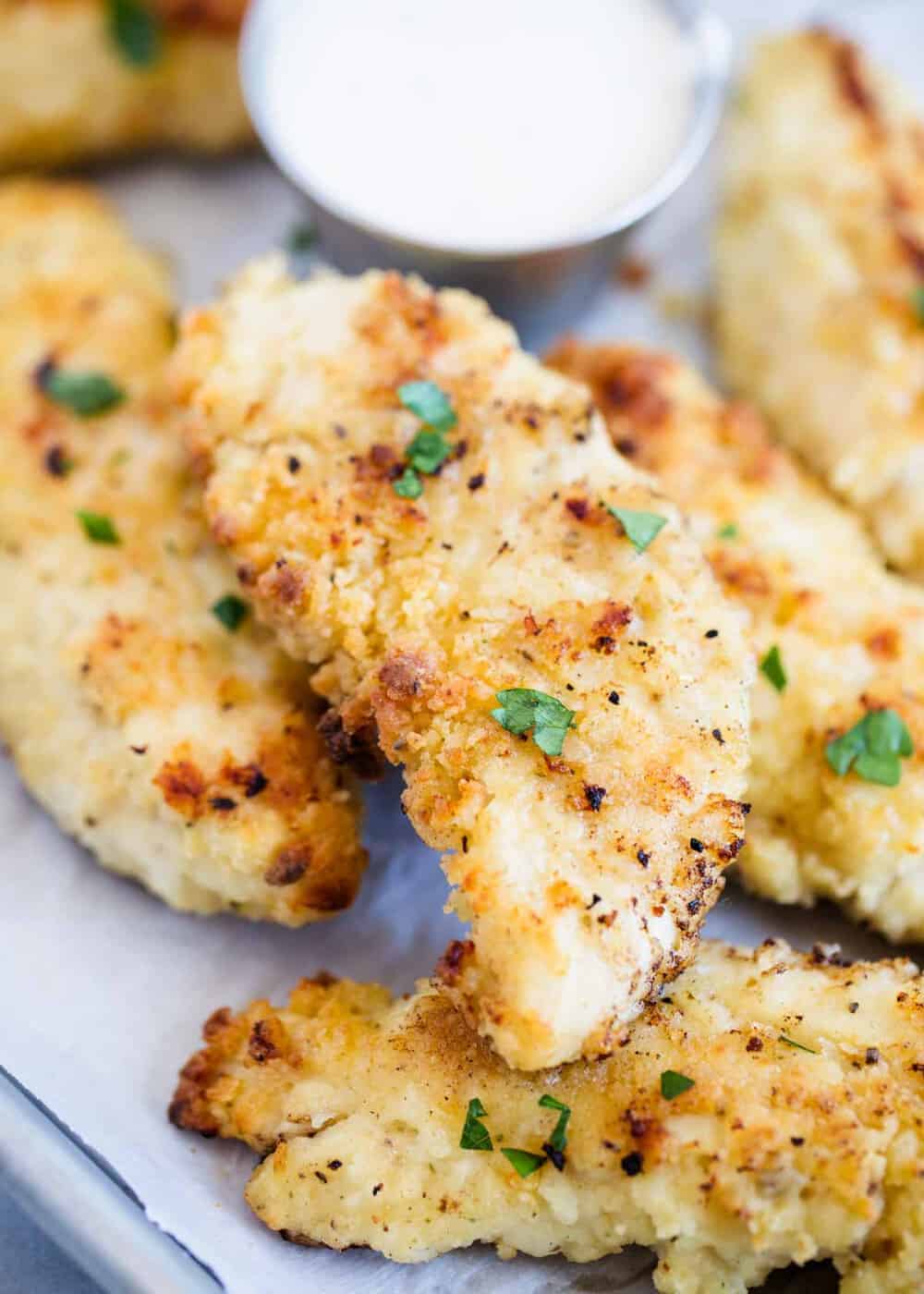 Crispy chicken tenders with parsley on top.