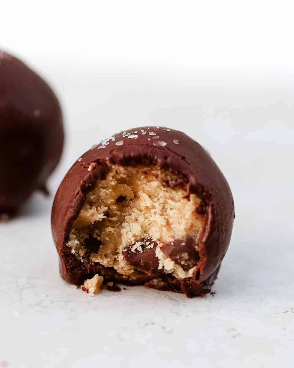 cookie dough truffle with a bite taken out 