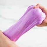 hands pulling purple slime