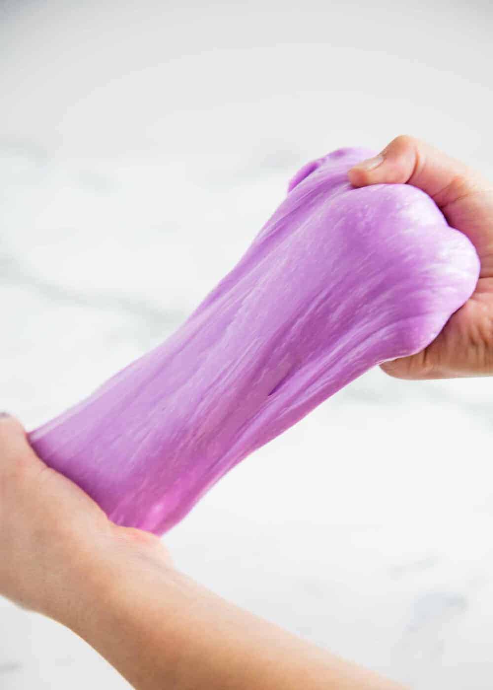 hands pulling purple slime