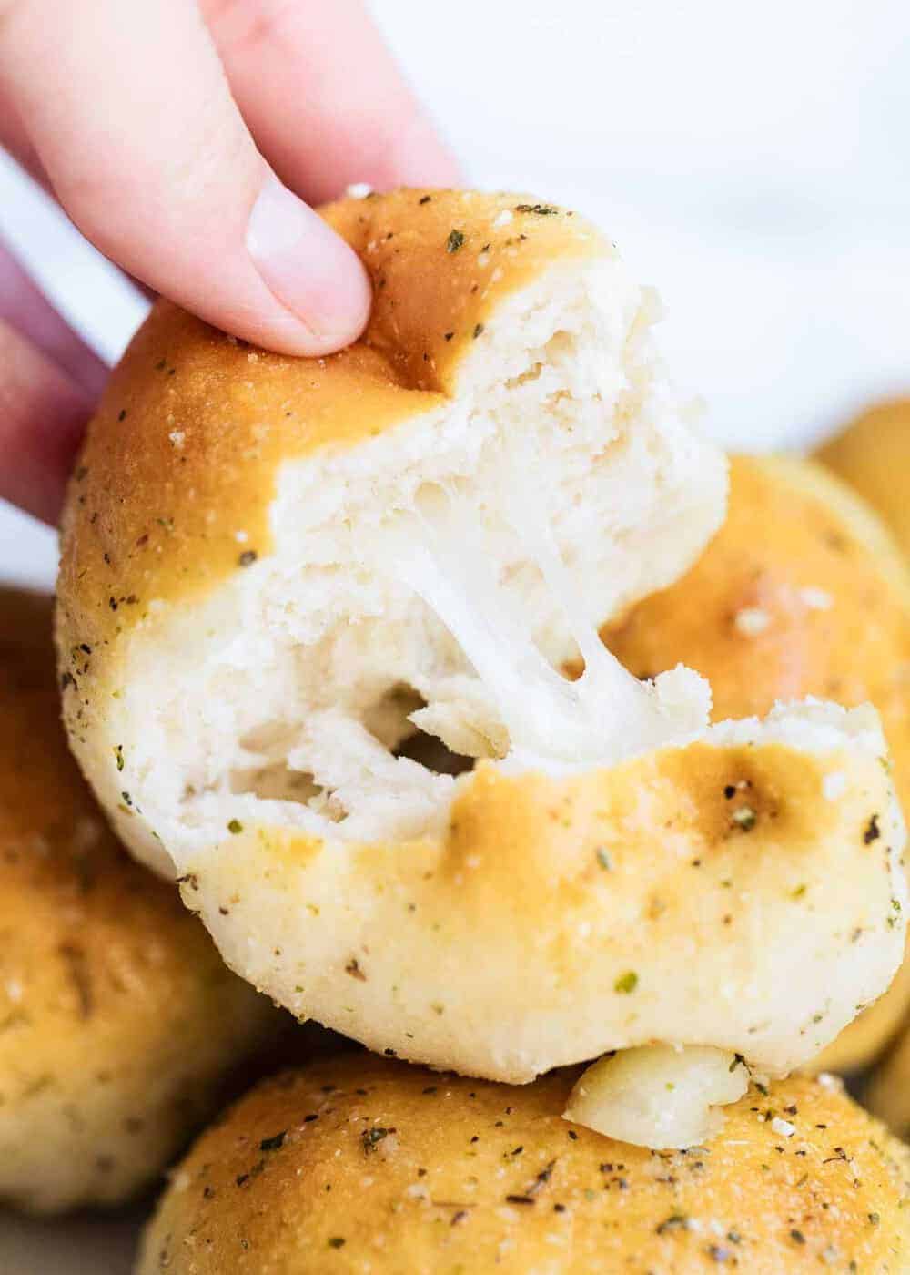 Pulling apart a cheesy garlic roll.