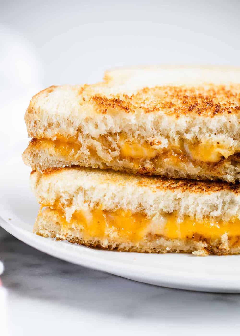 Sliced grilled cheese sandwich stacked on top of each other.