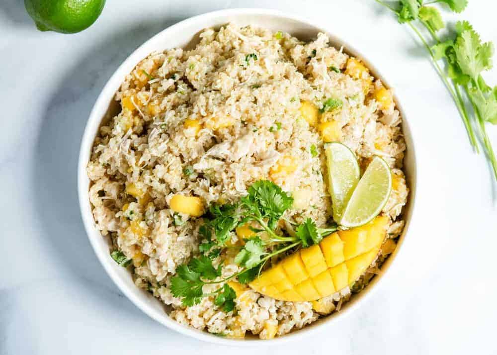 chicken quinoa salad with mango, lime and cilantro in white bowl