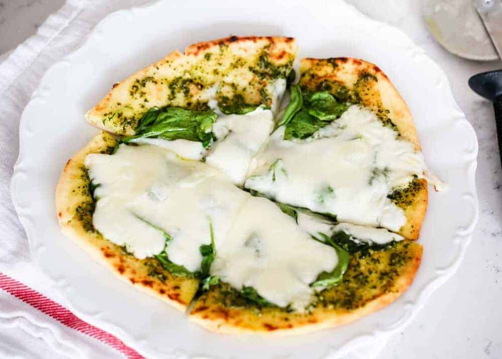 Pesto pizza with mozzarella melted on top.