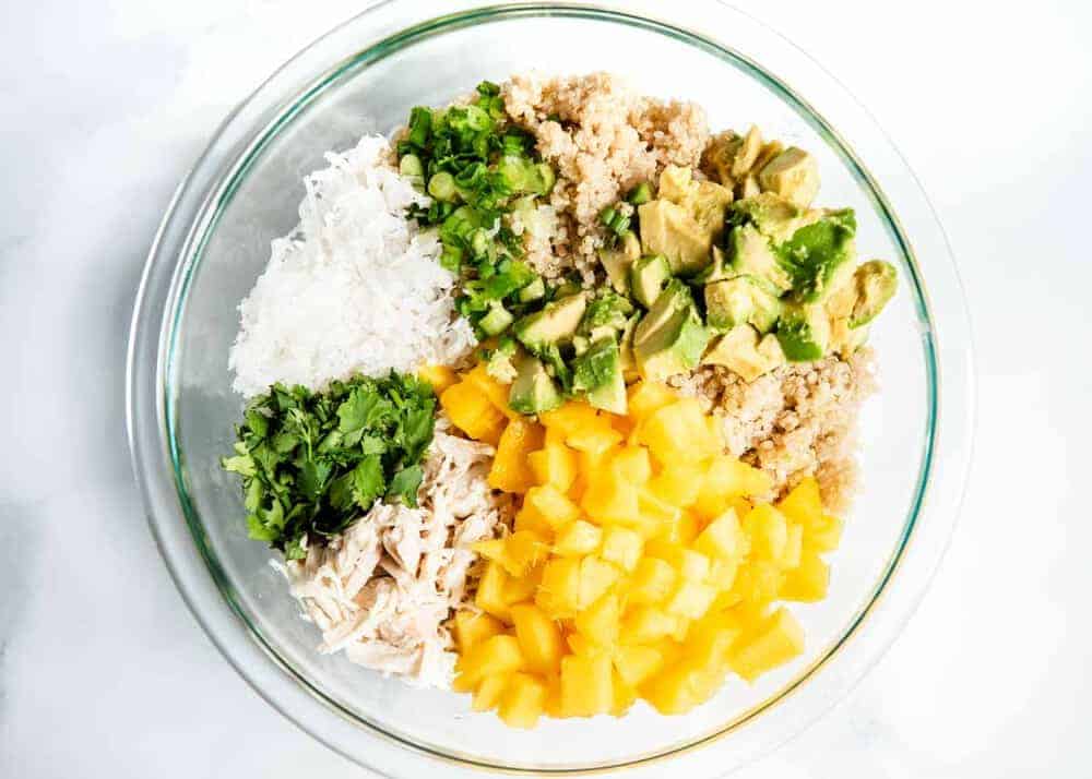 quino, avocado, chicken, mango, cilantro and onion in a bowl