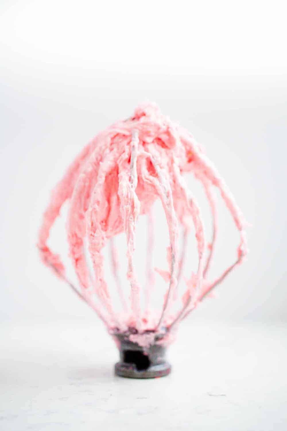 raspberry buttercream frosting on a whisk