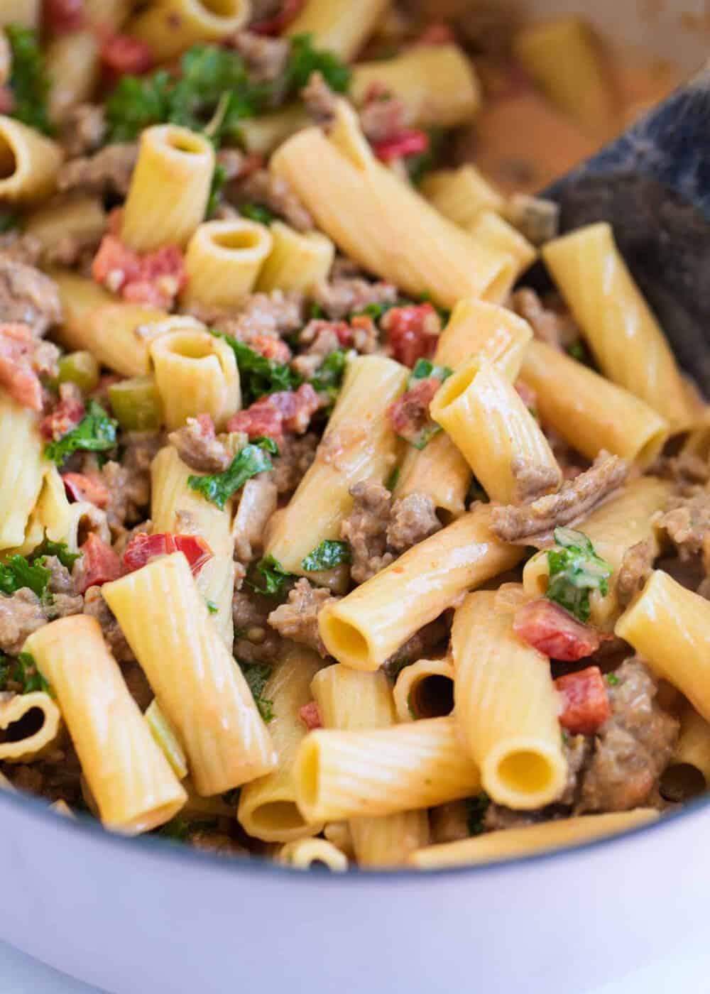 Rigatoni noodles with bolognese sauce in pan.