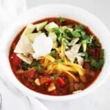 Bowl of taco soup with toppings.