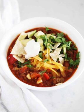 Bowl of taco soup with toppings.