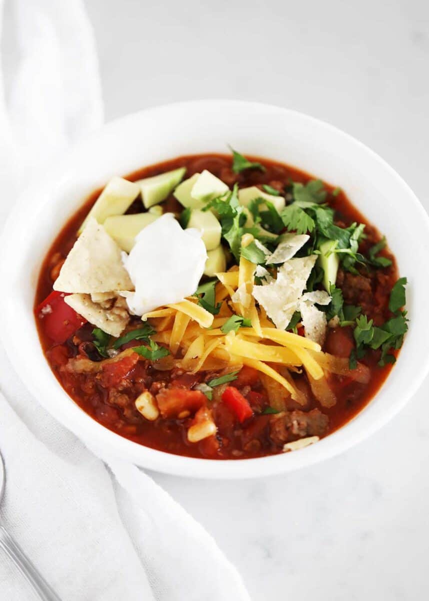 Bowl of taco soup with toppings. 