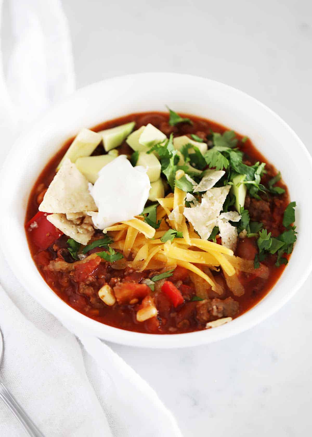 Bowl of taco soup with toppings.