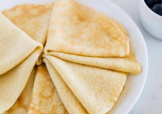 folded crepes on a white plate