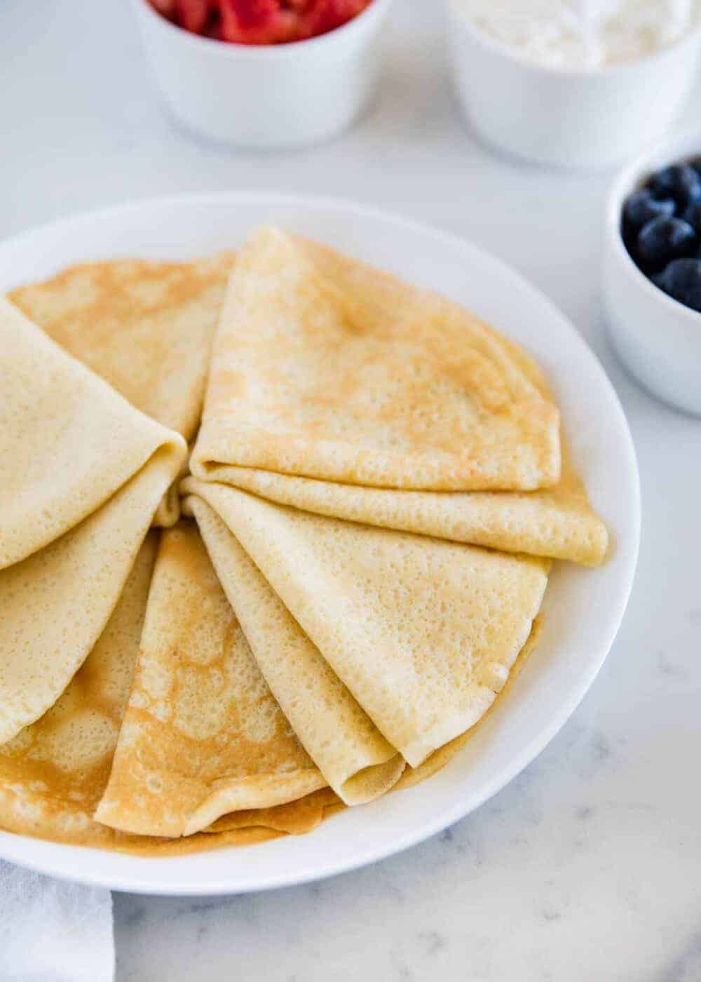 crepes folded into triangles on a white plate 