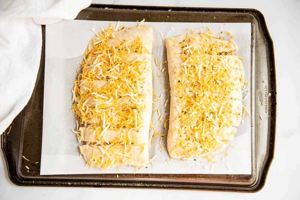 Cheesy bread laying on top of upside down cookie sheet.