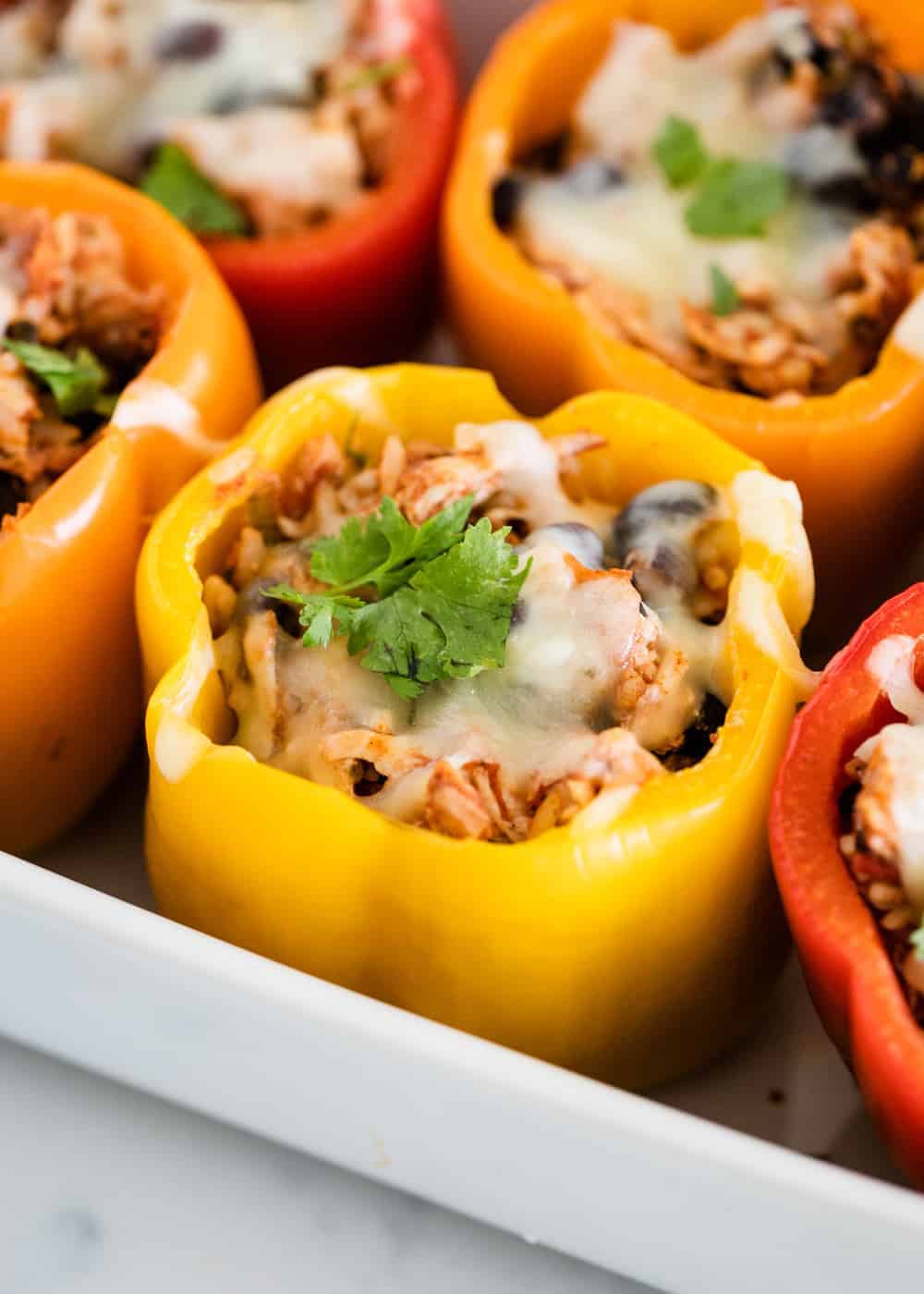 Chicken stuffed bell pepper topped with cheese and cilantro.