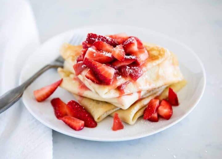 plate of crepes with strawberry crepe filling on top