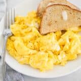 scrambled eggs on white plate with toast