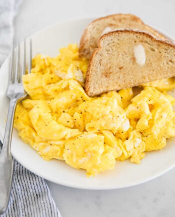 scrambled eggs on white plate with toast
