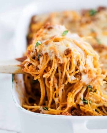 baked spaghetti being dished out of pan