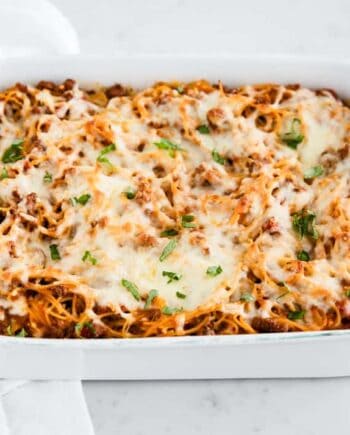 Baked spaghetti with hearty meat sauce and cheeses baked in a casserole dish.
