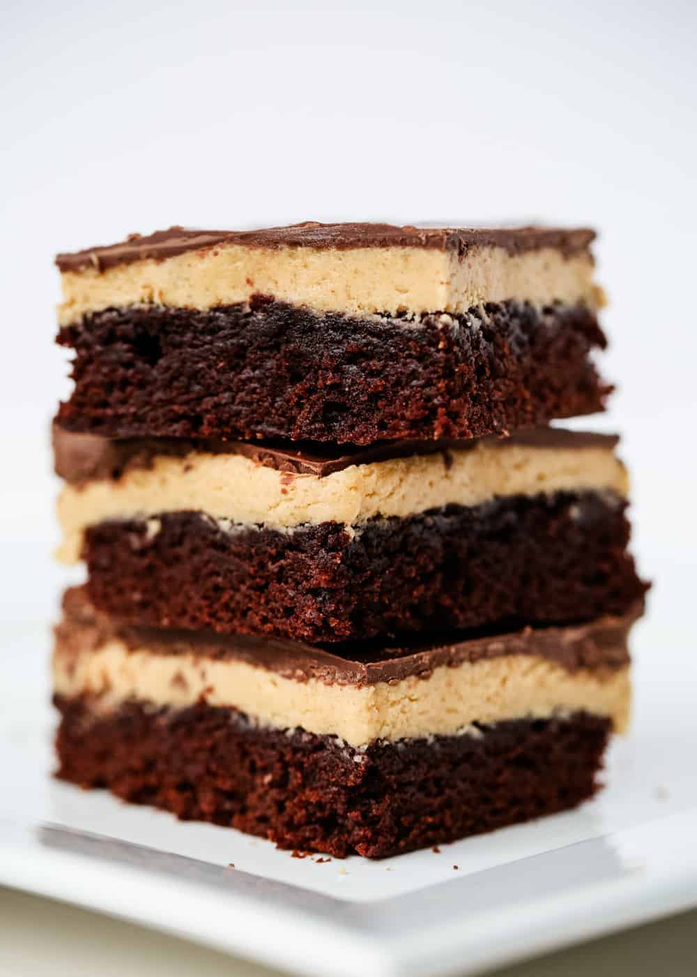 Stack of buckeye brownies on a white plate.