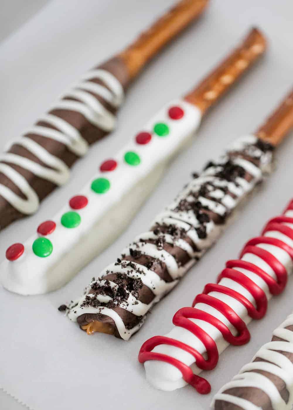 Chocolate covered pretzel rods with toppings.