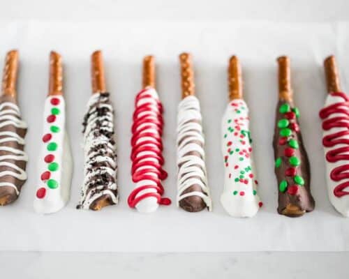chocolate covered pretzel rods on parchment paper