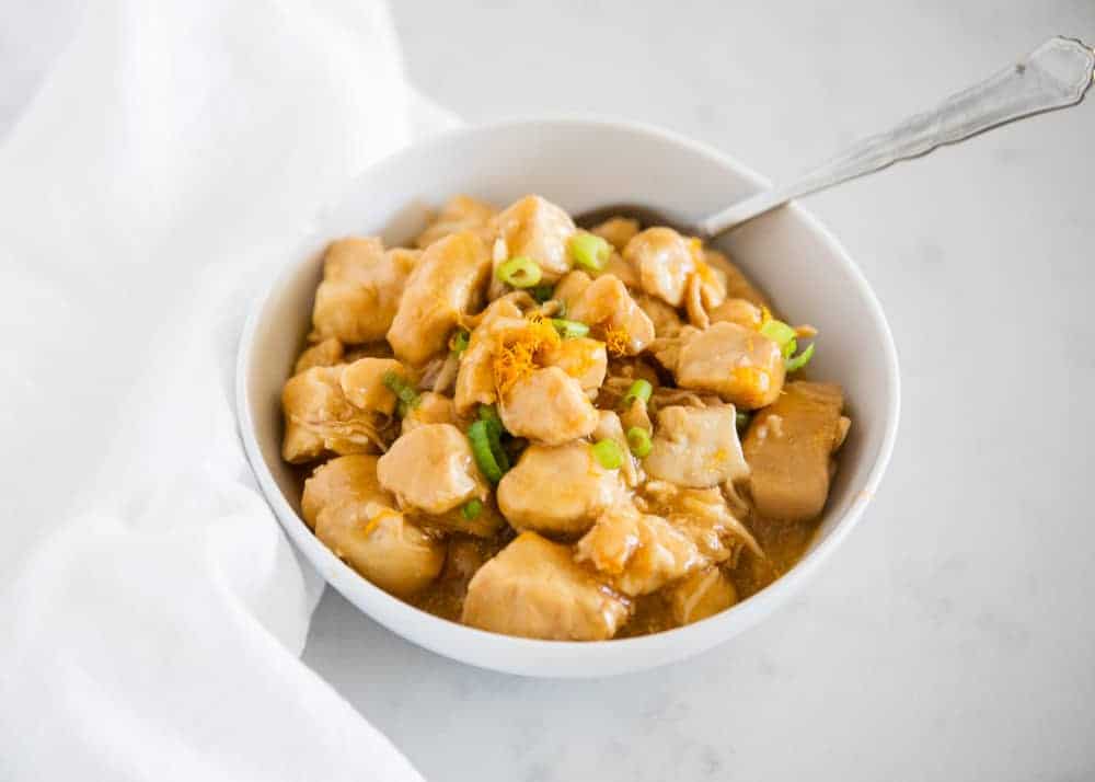 Orange chicken in white bowl.