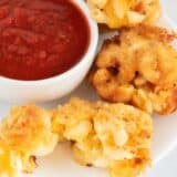 fried mac and cheese balls on a plate with marinara sauce