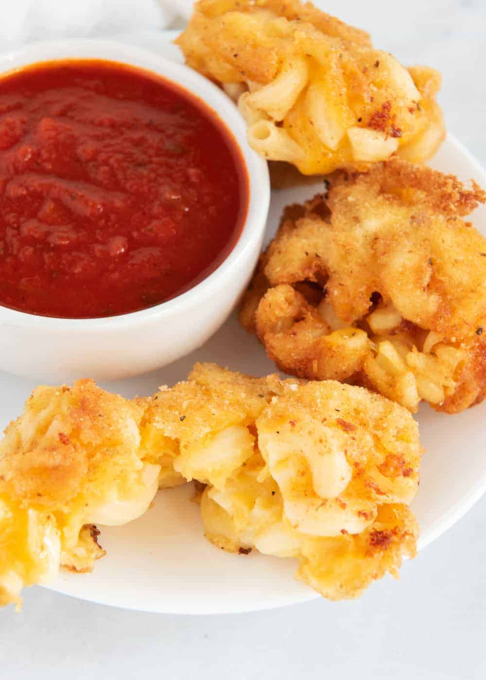 Fried macaroni and cheese with a bowl of marinara.