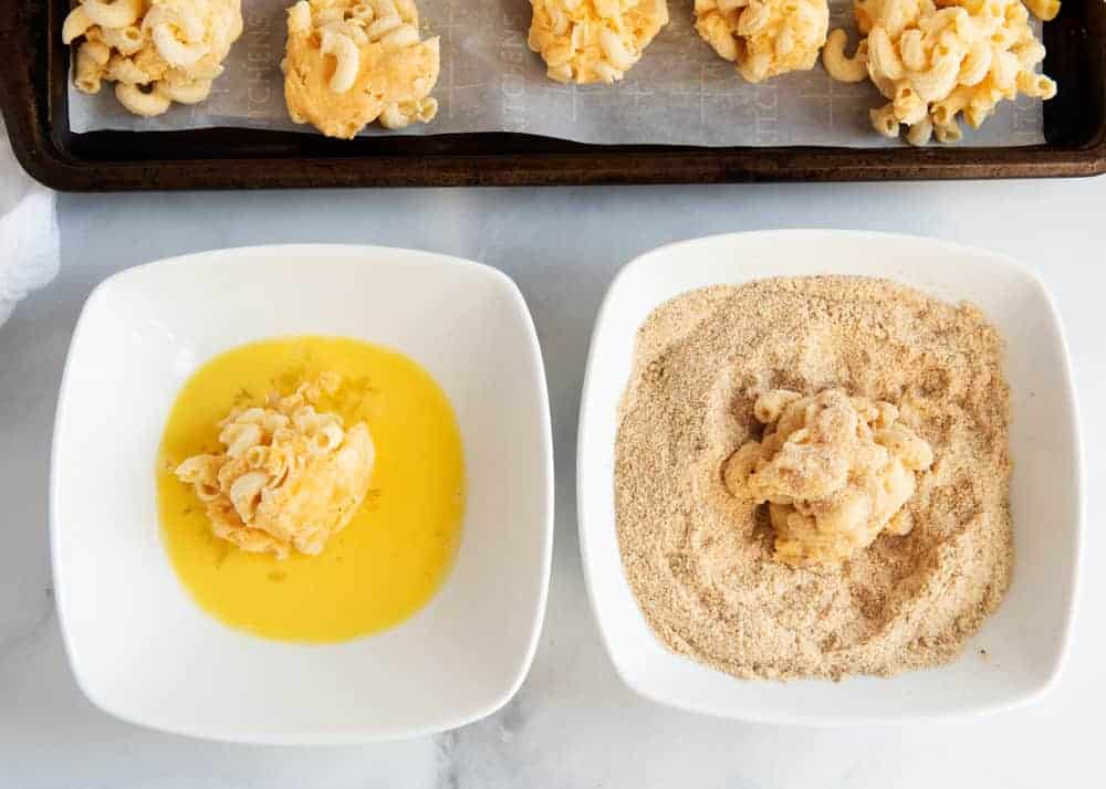 Coating mac and cheese balls in egg wash and breadcrumb mixture.